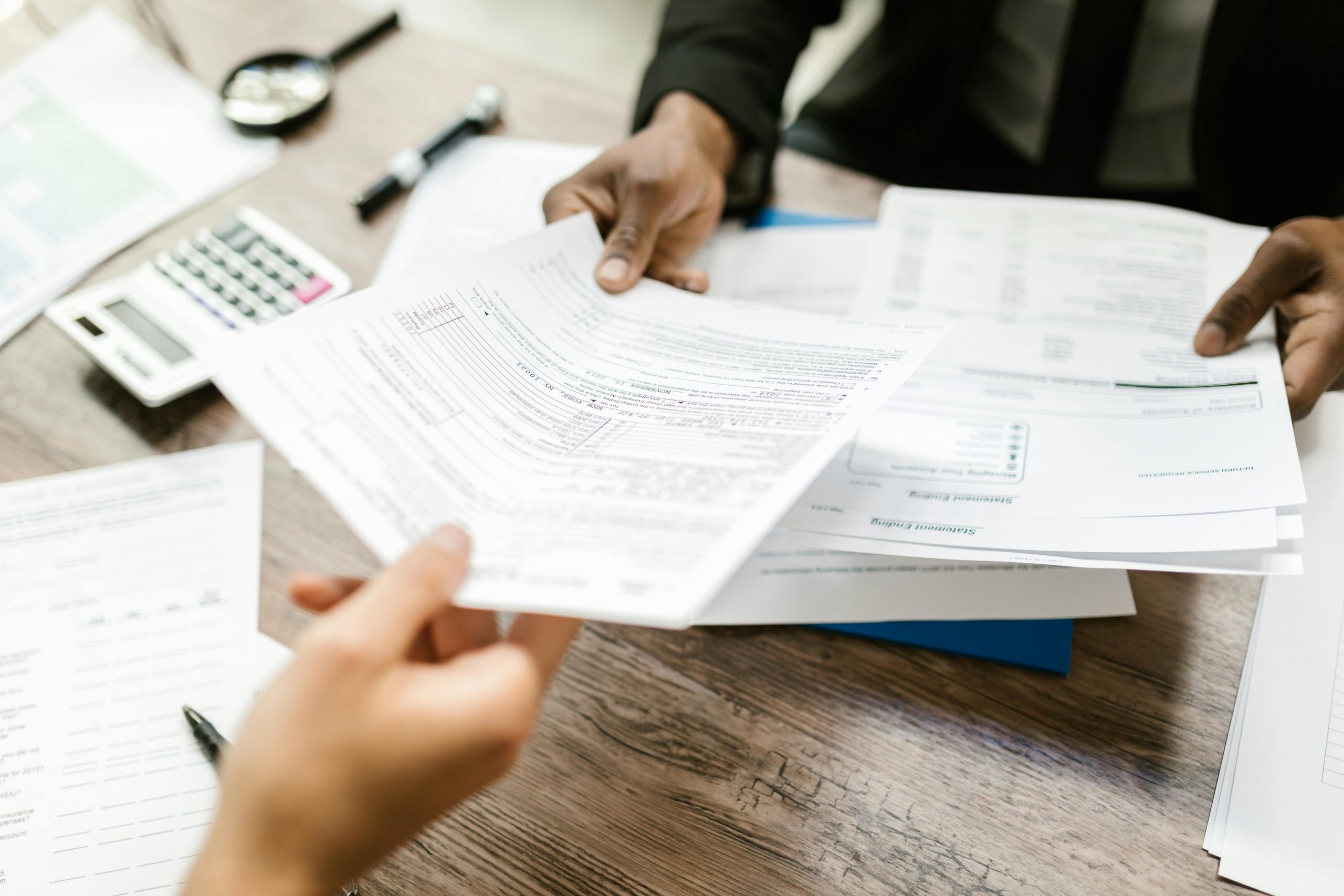Hands exchanging financial documents, symbolizing the need for stricter disclosure of industry payments to doctors in medical education.