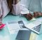 Researchers and students collaborating with journals and laptops, highlighting the need for nationwide access to scholarly research under One Nation, One Subscription.