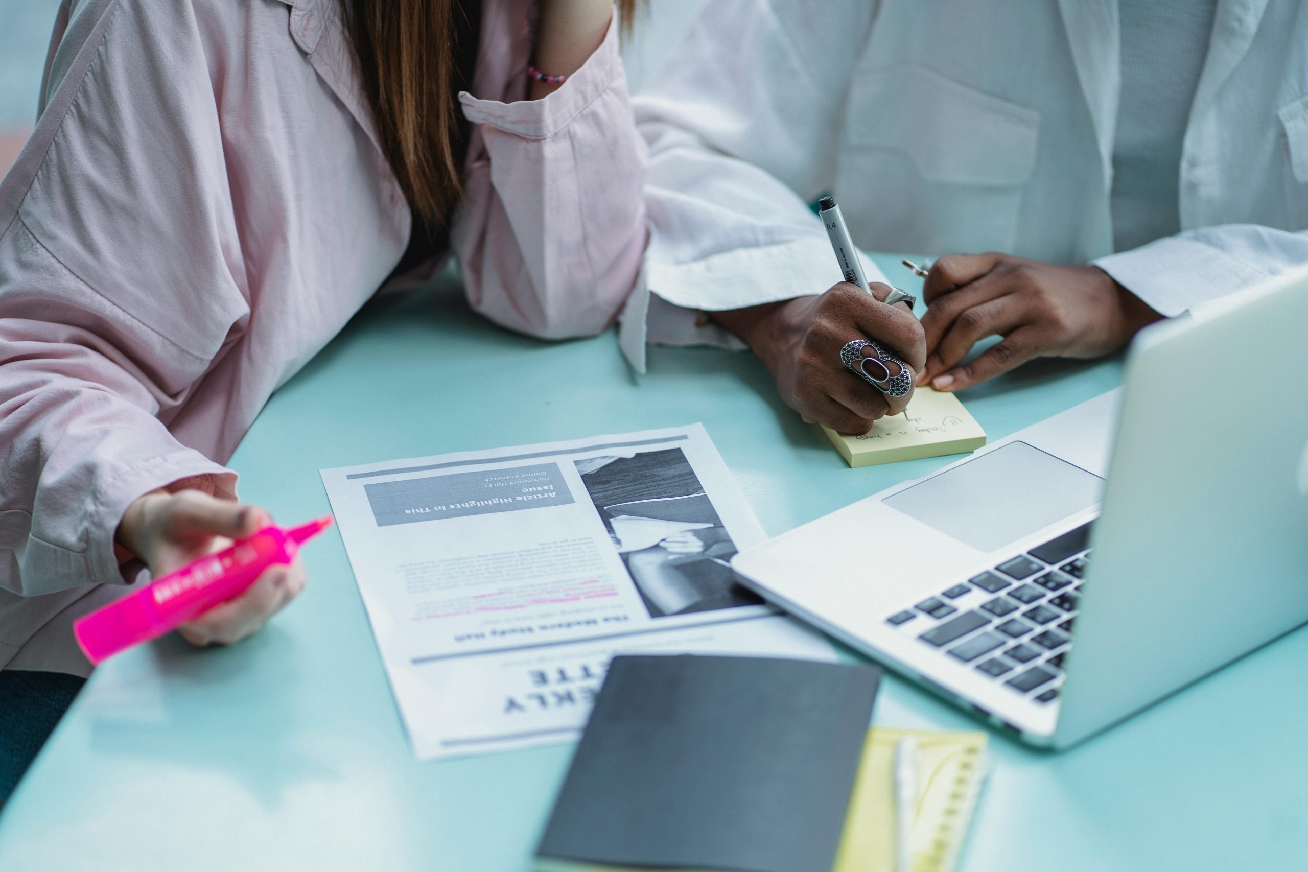 Researchers and students collaborating with journals and laptops, highlighting the need for nationwide access to scholarly research under One Nation, One Subscription.